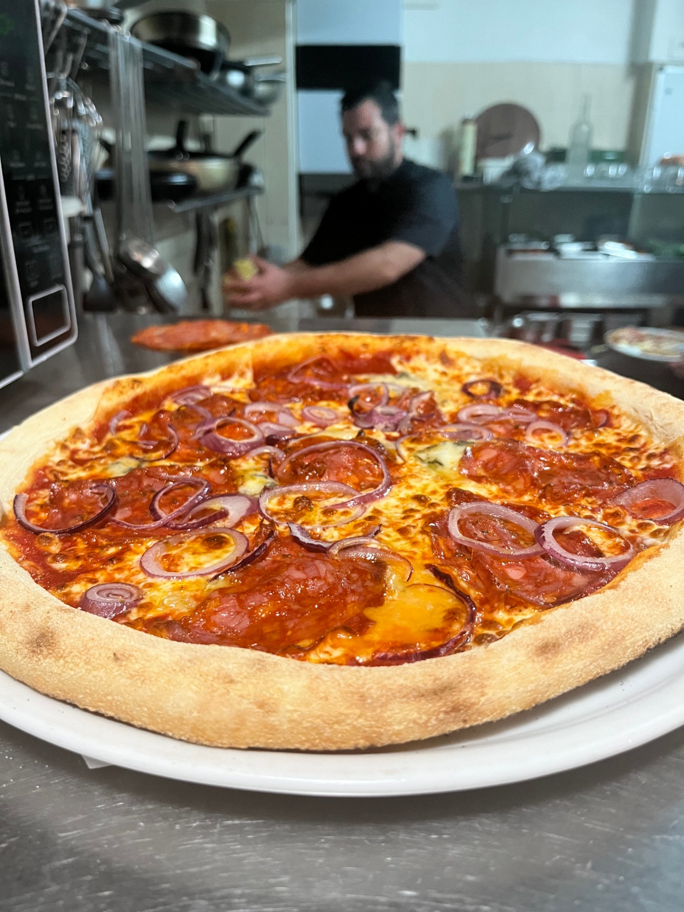 Pizza diavola au saucisson pimenté et oignons rouges, le chef en cuisine — Un Filo d'Olio, Saujon