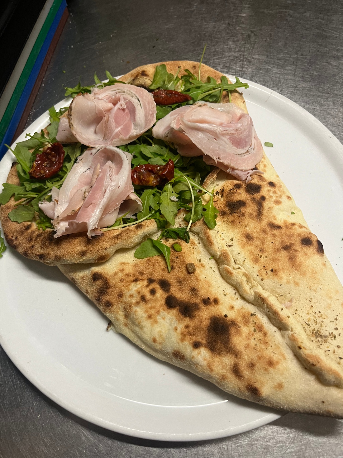 Calzone ouverte, jambon cuit, roquette et tomates séchées