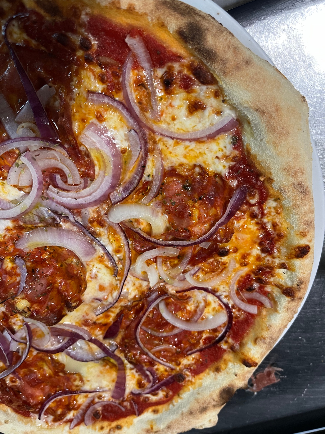 Gros plan sur une pizza diavola aux oignons rouges